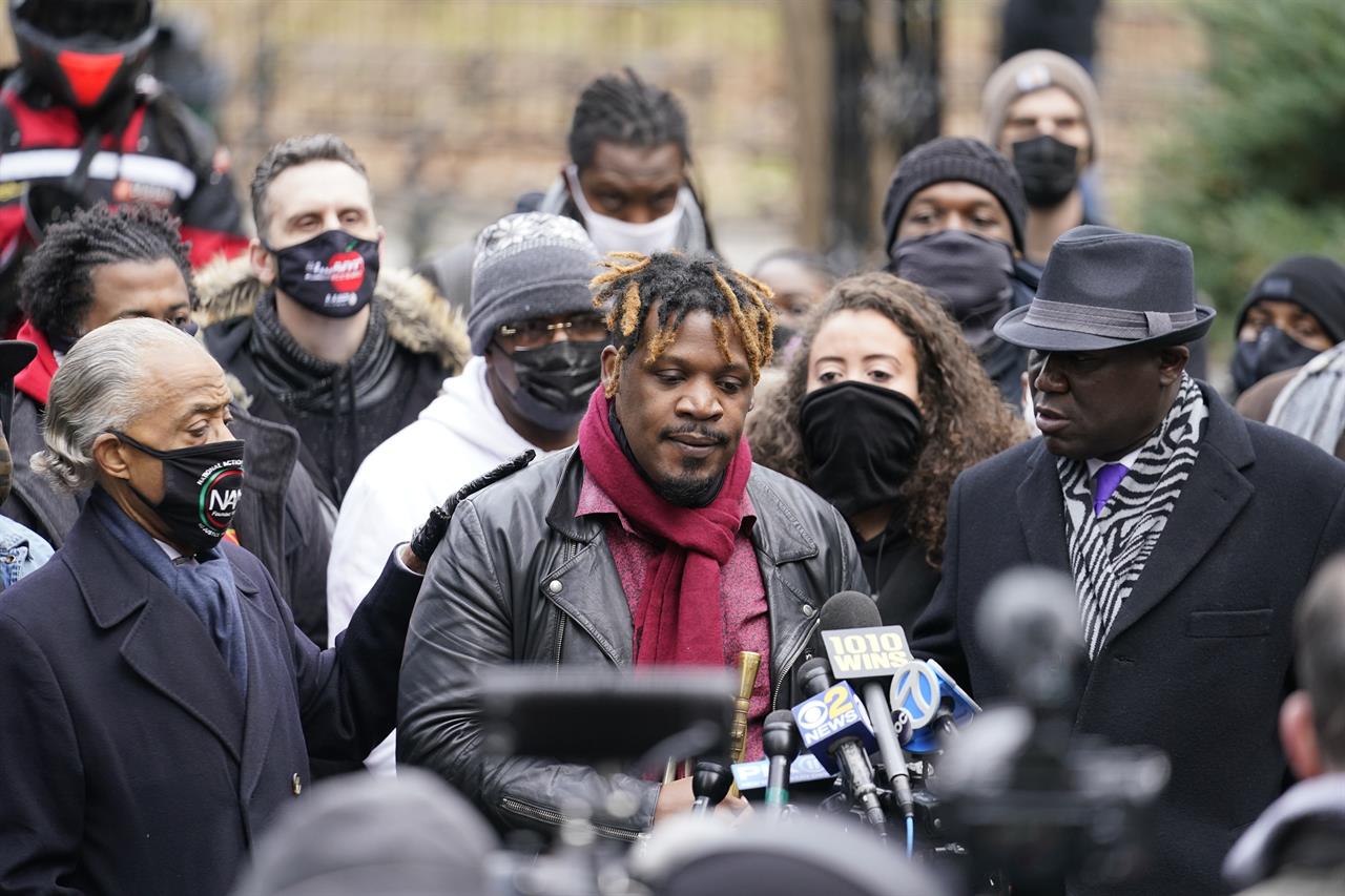 Attorney Ben Crump, right, listens as Rev. Al Sharpton, left, comforts Keyon Harrold Sr., during a news conference Wednesday, Dec. 30, 2020, in New York. New York City prosecutors say they are investigating a confrontation in which Harrold said a woman tackled his 14-year-old son in a New York City hotel lobby as she falsely accused the Black teen of stealing her phone. Harrold, a prominent jazz trumpeter, posted a widely viewed video of the confrontation Saturday at the Arlo Hotel. (AP Photo/Frank Franklin II)