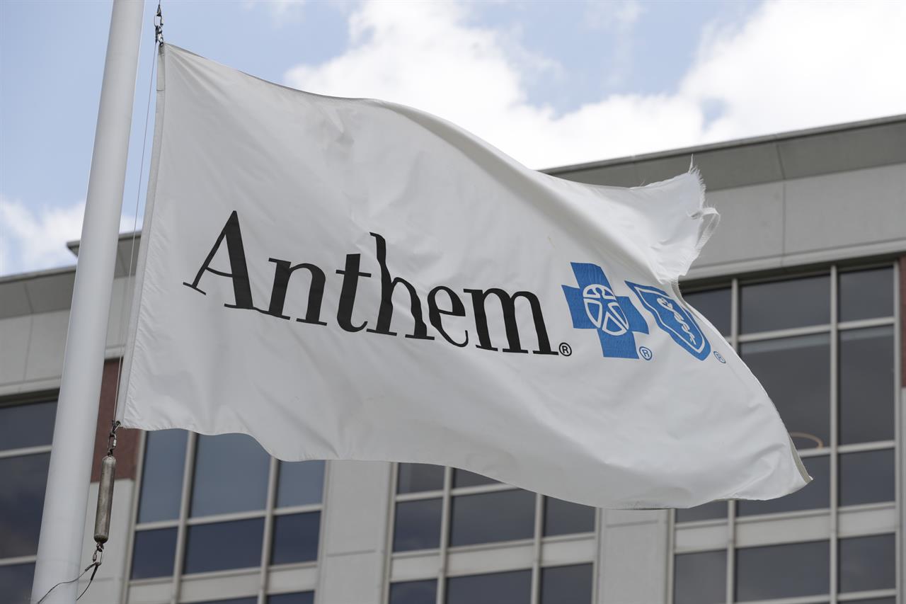 FILE - In this May 14, 2019, file photo a flag flies outside the corporate headquarters building of health insurance company Anthem in Indianapolis. Anthem delivered a better-than-expected first quarter and pushed its 2021 forecast past expectations, as growing enrollment and a pharmacy benefits business helped the health insurer. The Blue Cross-Blue Shield insurer said Wednesday, April 21, 2021, that it now expects full-year earnings to come in at greater than $25.10 per share. (AP Photo/Michael Conroy, File)