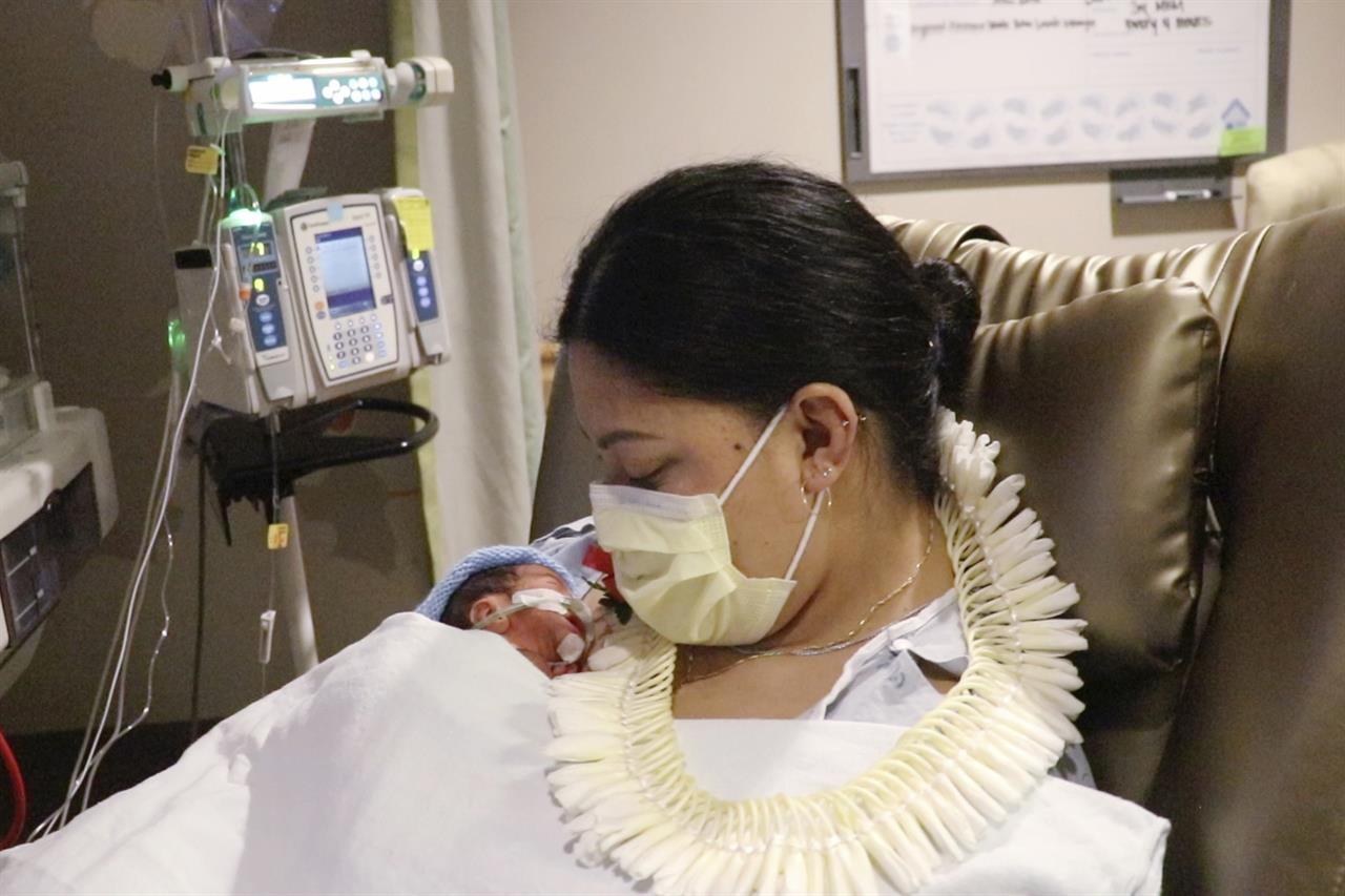 In this undated photo provided by Hawaii Pacific Health, Lavinia "Lavi" Mounga holds her son Raymond Mounga at Kapiolani Medical Center for Women & Children in Honolulu. Mounga had no idea the baby was coming when she went into labor on a flight from her home in Utah to Honolulu the week before. "I just didn't know I was pregnant, and then this guy just came out of nowhere," Mounga said during a video interview with Hawaii Pacific Health. The baby boy arrived early at just 29 weeks while mom was traveling to Hawaii for vacation with her family. (Taylor Ursulum/Hawaii Pacific Health via AP)