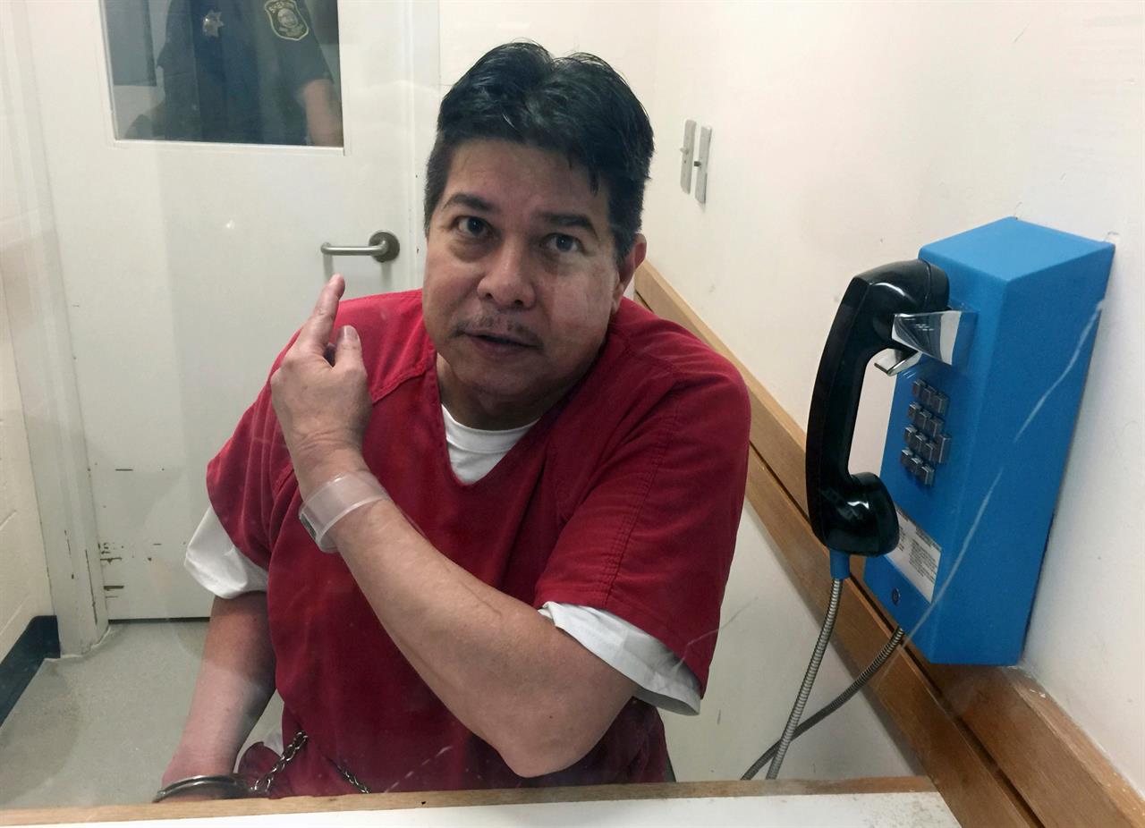FILE - In this Nov. 17, 2017, file photo, escaped hospital patient Randall Saito points to a guard as he sits in an inmate visitor's booth at San Joaquin County Jail before a scheduled court hearing in French Camp, Calif. Saito spent decades in a Hawaii psychiatric hospital for killing a woman and was sentenced to five years in prison Thursday, May 6, 2021, for escaping from the facility in 2017 and flying to California before he was captured. (AP Photo/Terry Chea, File)