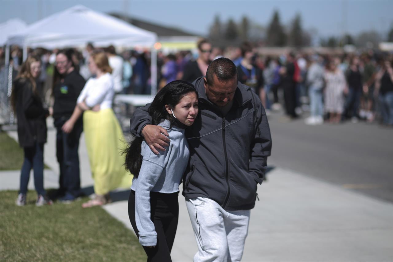 People embrace after a school shooting at Rigby Middle School in Rigby, Idaho on Thursday, May 6, 2021. Authorities say a shooting at the eastern Idaho middle school has injured two students and a custodian, and a male student has been taken into custody. (John Roark /The Idaho Post-Register via AP)