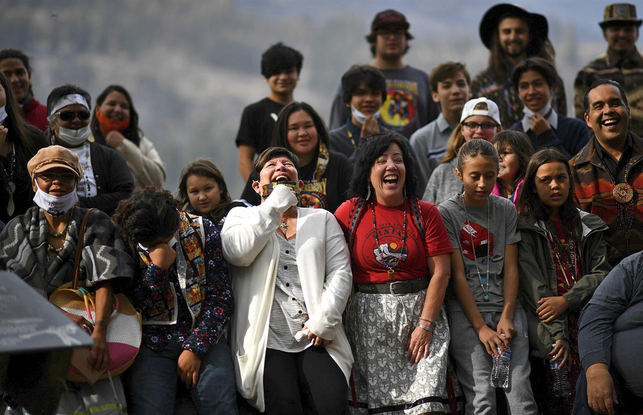 Linda Desautel, center in white, looks skyward and cheers with friends and Colville Confederated Tribe members as they rally in support of her husband Rick Desautel, whose case in the Canadian Supreme court arguing for the Sinixt peoples' right to hunt traditional lands in Canada was first heard, on Thursday, Oct. 8, 2020, near Kettle Falls, Wash. It's been 50 years since the Confederated Tribes of the Colville Reservation voted against termination, effectively ending the federal government's experiment in abrogating treaties, eliminating funding and "freeing the Indians" from the Bureau of Indian Affairs. More than 100 tribes were terminated by the United States — but not one after the 12 bands that make up the reservation in Washington state crushed the idea at the ballot box. (Tyler Tjomsland/The Spokesman-Review via AP)