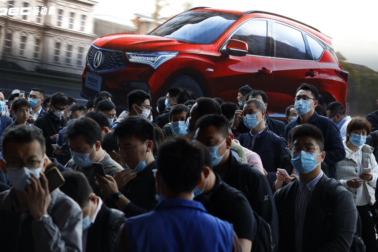 FILE - In this April 21, 2021, file photo, visitors attend the Shanghai Auto Show in Shanghai. The United Nations has responded to the rebounding Chinese and U.S. economies by revising its global economic forecast upward to 5.4% for 2021. But it warned that surging COVID-19 cases and inadequate availability of vaccines in many countries threaten a broad-based recovery. (AP Photo/Ng Han Guan, File)