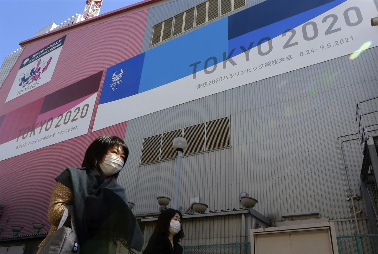 FILE - In this Feb. 24, 2021, file photo, people walk past posters to promote the Olympic Games scheduled to start in the summer in Tokyo. Frustration is mounting over Japanese Prime Minister Yoshihide Suga’s request that people cooperate while he pushes to hold the Olympics in just over two months. (AP Photo/Koji Sasahara, File)