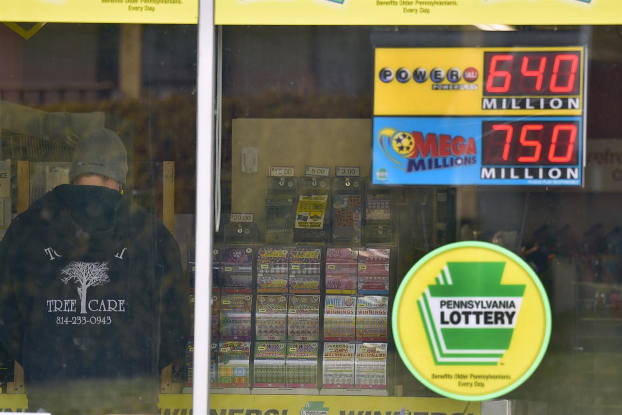 A lottery customer purchases lottery tickets at Conjelko's Dairy Store in Windber, Pa., as the Mega Millions grew to $750 million and the PowerBall to $ 640 Million on Thursday, Jan. 14, 2021. (Todd Berkey/The Tribune-Democrat via AP)