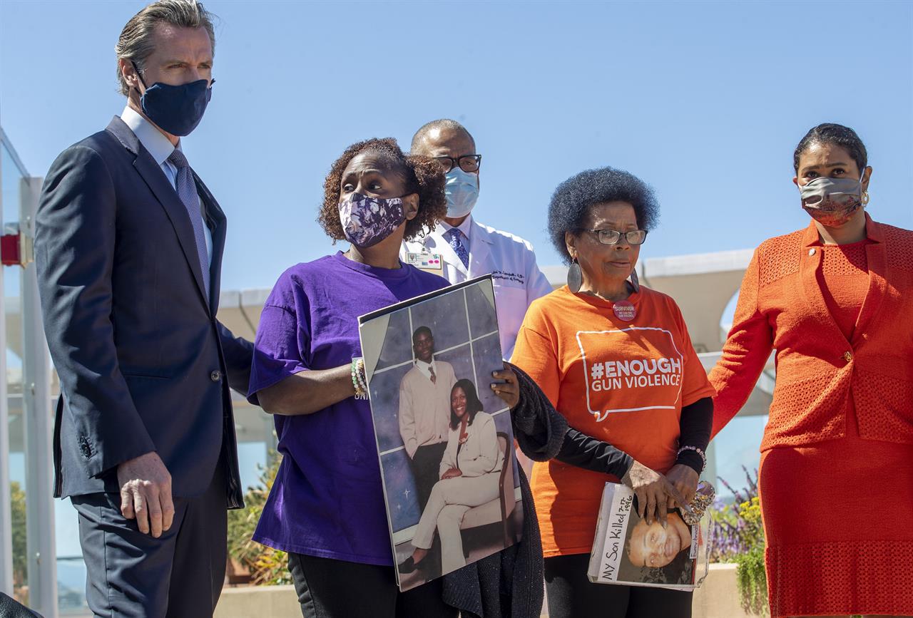 California Gov. Gavin Newsom, left, and San Francisco Mayor London Breed stand with Sheila Burton and Mattie Scott of the Brady Center to Prevent Gun Violence during a press conference at Zuckerberg General Hospital in San Francisco, Thursday, June 10, 2021. Gov. Newsom denounced in starkly personal terms a federal judge's upending of the state's restrictions on assault weapons as officials announced the filing Thursday of a formal notice that they will appeal the decision. (Karl Mondon/Bay Area News Group via AP)