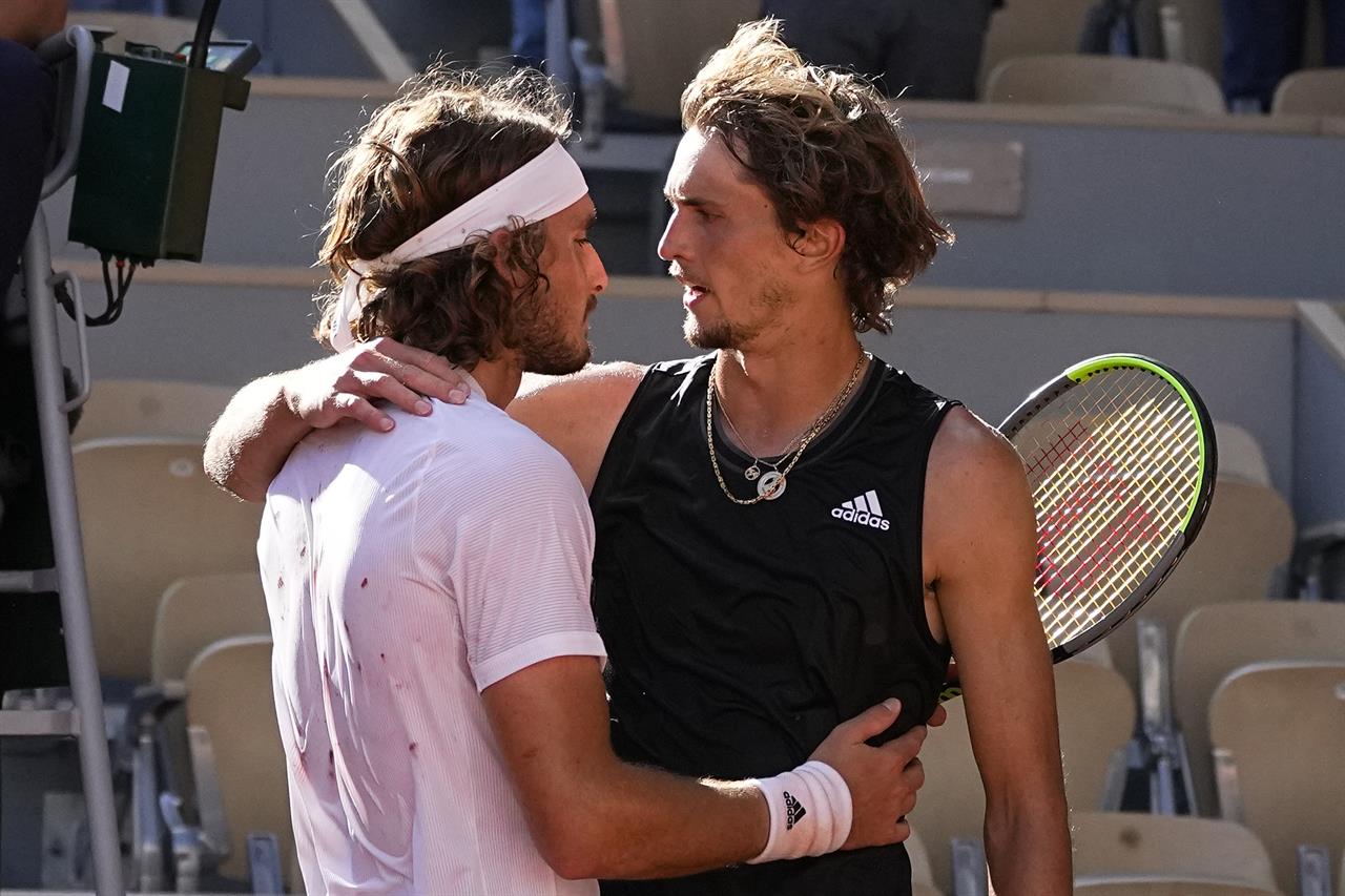 Stefanos Tsitsipas of Greece, left, hugs Germany's Alexander Zverev after their semifinal match of the French Open tennis tournament at the Roland Garros stadium Friday, June 11, 2021 in Paris. Tsitsipas won 6-3, 6-3, 4-6, 4-6, 6-3. (AP Photo/Michel Euler)