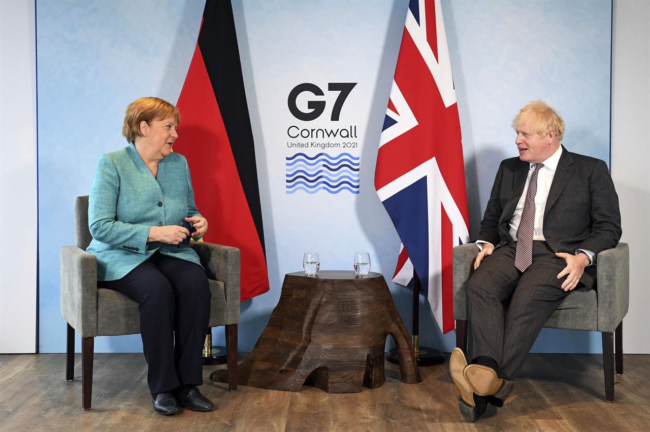 Britain's Prime Minister Boris Johnson, right, and German Chancellor Angela Merkel ahead of a bilateral meeting during the G7 summit in Cornwall, England, Saturday June 12, 2021. (Stefan Rousseau/Pool via AP)