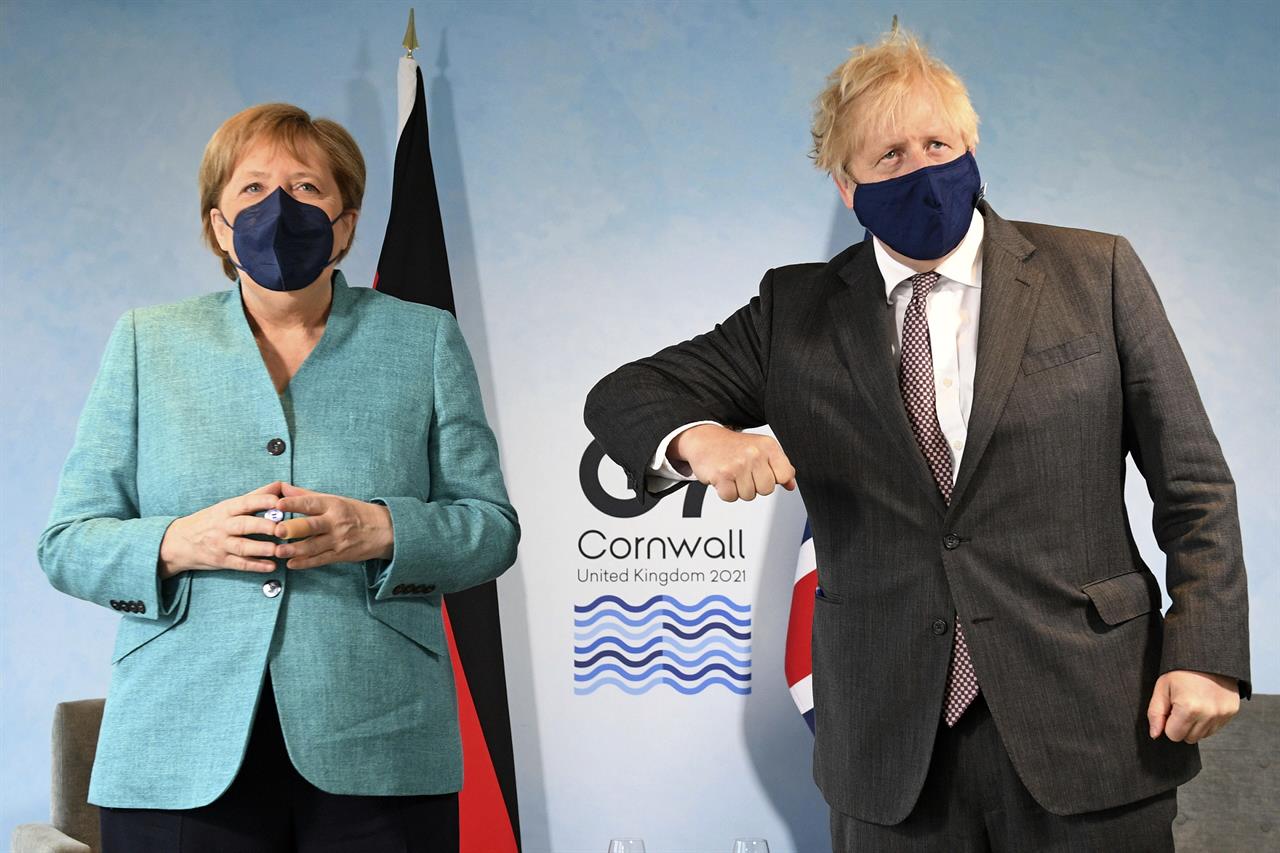 Britain's Prime Minister Boris Johnson, right, greets German Chancellor Angela Merkel ahead of a bilateral meeting during the G7 summit in Cornwall, England, Saturday June 12, 2021. (Stefan Rousseau/Pool via AP)