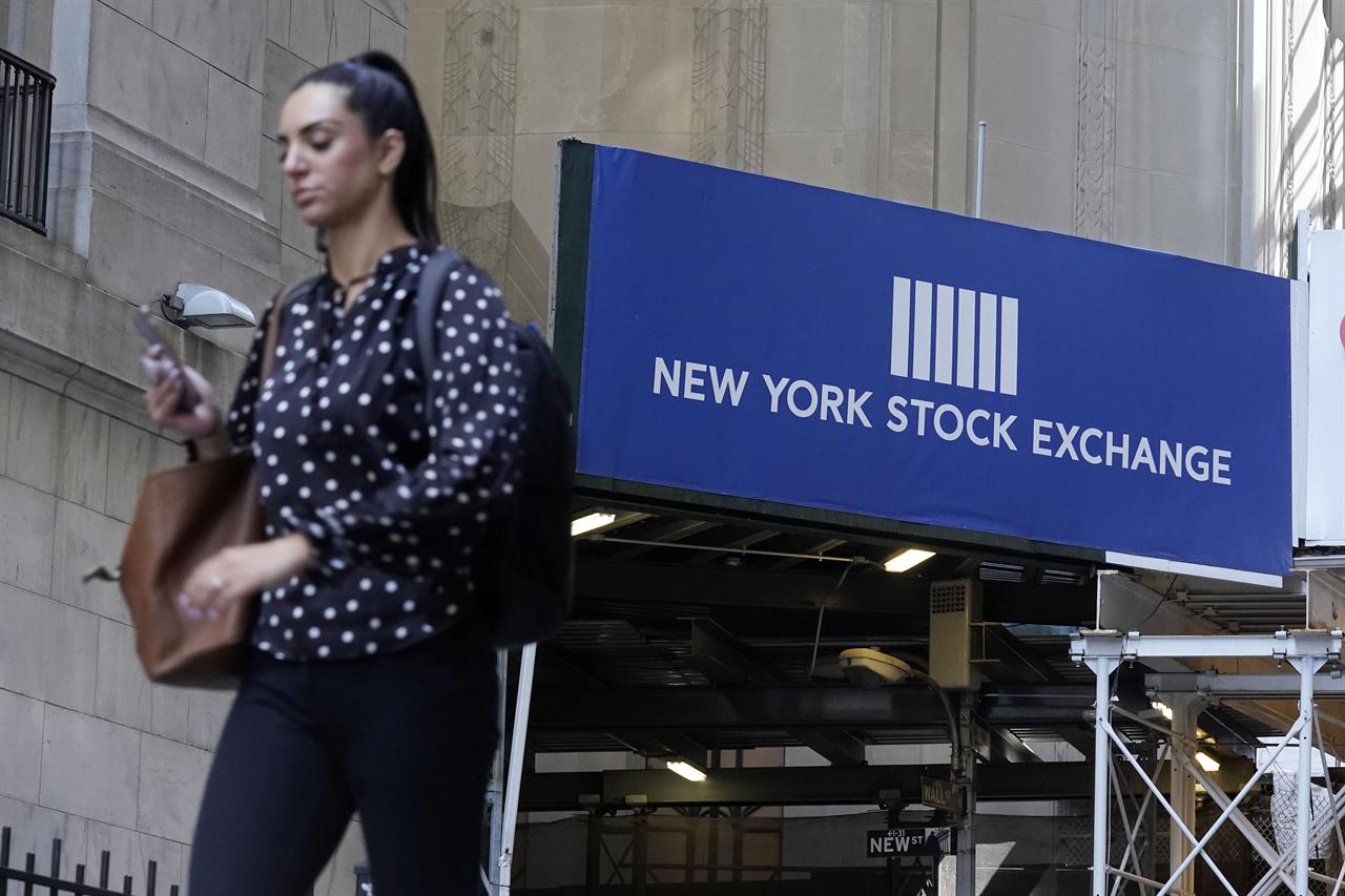 A woman passes an entrance of the New York Stock Exchange, Wednesday, June 16, 2021. Stocks are opening broadly lower on Wall Street, putting the S&P 500 index on track for its first losing week in the last four. The benchmark index gave up 0.8% in the early going Friday, June 18 with banks and technology companies leading the way lower. (AP Photo/Richard Drew)
