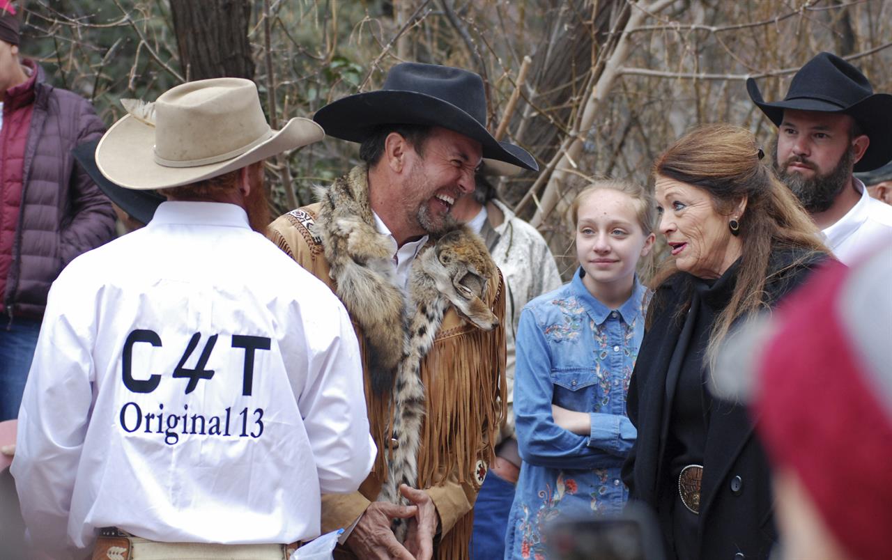 FILE - In this March 12, 2019, file photo, Cowboys for Trump leader and Otero County Commissioner Couy Griffin, center, talks with Republican New Mexico state Rep. Candy Ezzell of Roswell, N.M., at a protest against gun control and pro-abortion rights legislation outside the New Mexico state Capitol, in Santa Fe, N.M. The Mescalero Apache Tribe of New Mexico announced Monday, Sept. 28, 2020, that Griffin has been banned from tribal lands after posting a video of himself on the reservation laughing during a traditional Apache ceremony and referencing Democratic House Speaker Nancy Pelosi. (AP Photo/Morgan Lee,File)