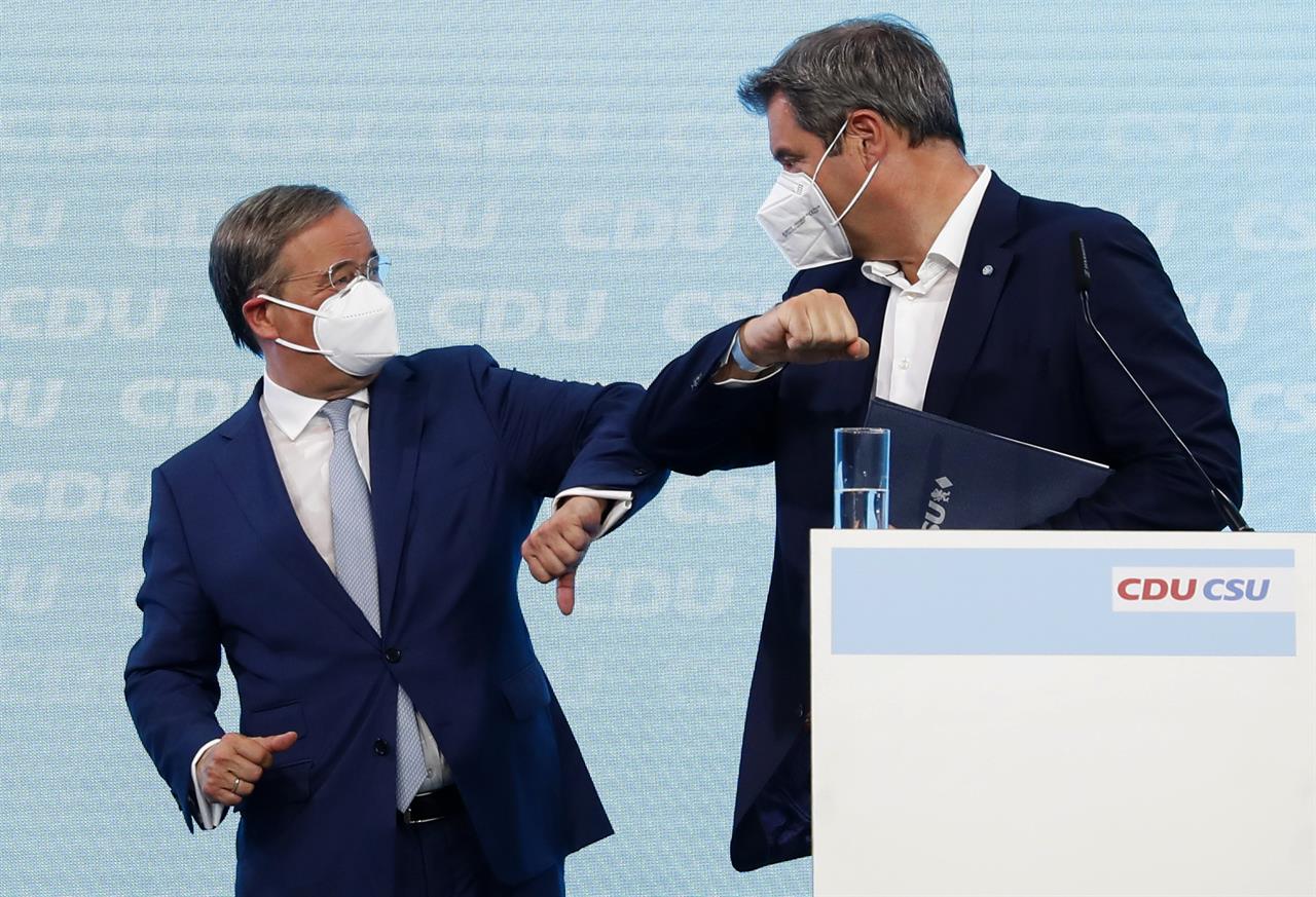 Christian Democratic Union (CDU) chairman Armin Laschet, left, and Christian Social Union (CSU) chairman Markus Soeder, right, bump elbows during a press conference in Berlin, Germany, Monday, June 21, 2021. (Michele Tantussi/Pool Photo via AP)