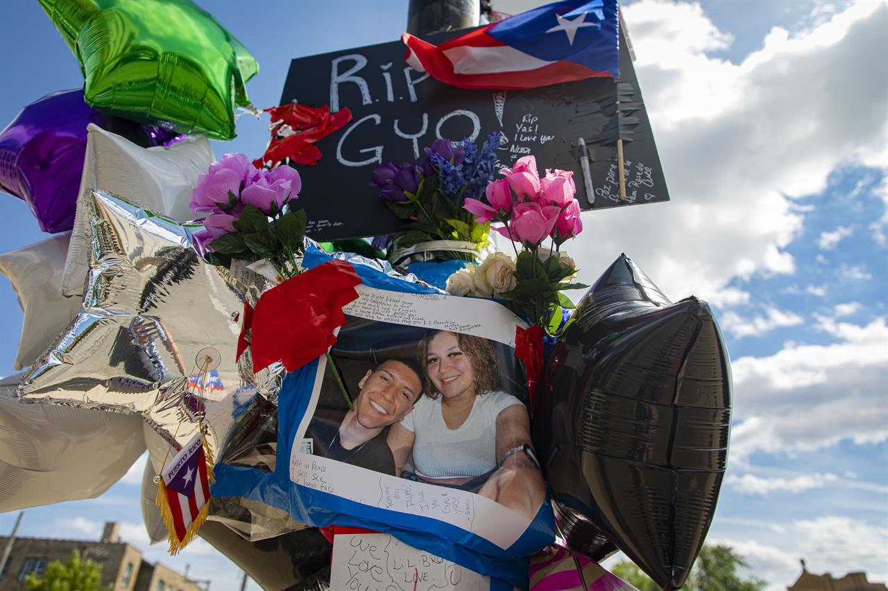A memorial to shooting victims Gyovanny Arzuaga, 24, and Yasmin Perez, 23, is attached to a pole Tuesday, June 22, 2021 at the corner of West Division Street and North Spaulding Avenue in Humboldt Park in Chicago. The Cook County medical examiner’s office says 23-year-old Yasmin Perez died Tuesday. Her death came three days after 24-year-old Gyovanny Arzuaga was shot in the head and killed following a Puerto Rican Day parade in Chicago’s Humboldt Park neighborhood. (Brian Cassella/Chicago Tribune via AP)