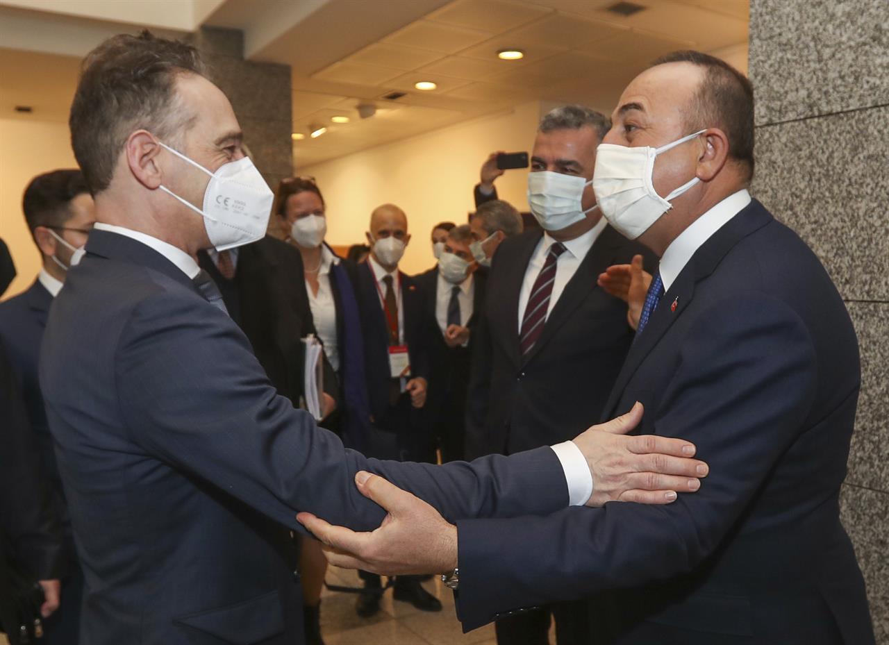 Turkey's Foreign Minister Mevlut Cavusoglu, right greets Germany's Foreign Minister Heiko Maas, left, prior to their meeting, in Ankara, Turkey, Monday, Jan. 18, 2021. (Turkish Foreign Ministry via AP, Pool)