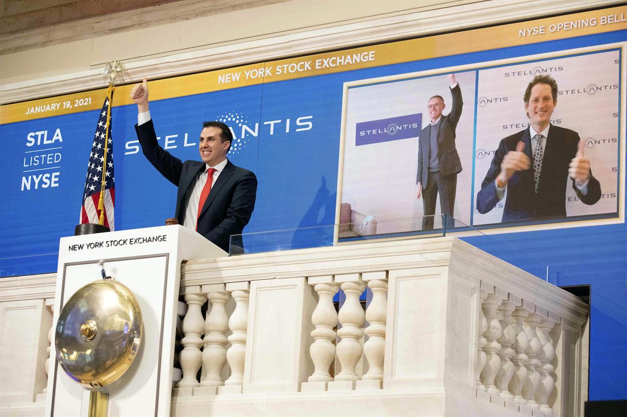 In this photo provided by the New York Stock Exchange, NYSE Vice Chairman John Tuttle, left, Stellantis CEO Carlos Taveras, center, and Chariman John Elkann, right, virtually ring the NYSE opening bell, Tuesday, Jan. 19. 2021. Stellantis shares start trading in New York in the new auto giant created by the merger of Fiat Chrysler and PSA Peugeot. (Colin Ziemer/New York Stock Exchange via AP)