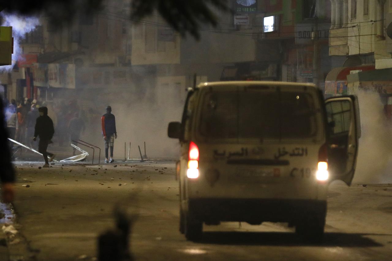 FILE - In this Jan.18, 2021 file photo, demonstrators face police officers during clashes in Ibn Khaldoun City near Tunis. A growing groundswell of youth unrest, tapping into a well of economic frustration, is sweeping Tunisia and worrying its leadership all the way to the top. It is, after all, the country that triggered 2011's Arab Spring revolutions. (AP Photo/Hassene Dridi, File)