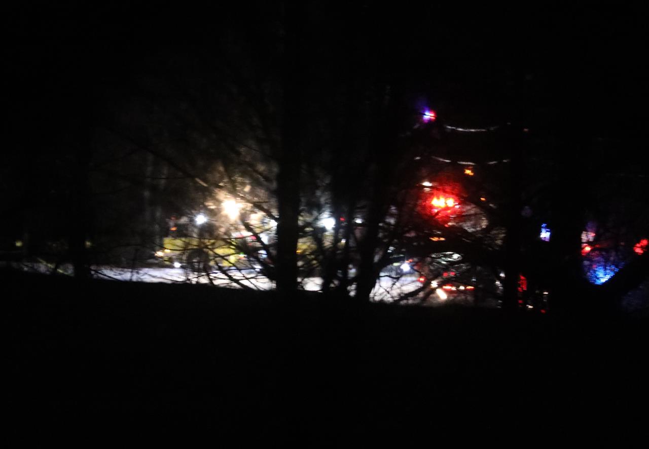 Mendon firefighters and other emergency personnel respond to a military helicopter crash in a field near Cheese Factory Road and W. Bloomfield Road in Mendon, N.Y., late Wednesday, Jan. 20, 2021. Three National Guard members on the routine training flight were killed, according to authorities. (Tina MacIntyre-Yee/Democrat & Chronicle via AP)
