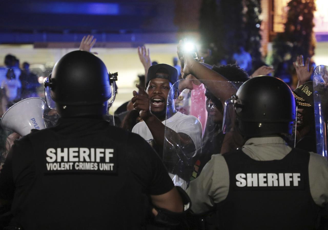 A protester confronts police officers in riot gear on Thursday night, June 24, 2021 in downtown Rock Hill, S.C. Two nights of protests outside a South Carolina police station have followed the arrest of two men seen on a Facebook video being wrestled and punched by Rock Hill officers. (Tracy Kimball/The Charlotte Observer via AP)