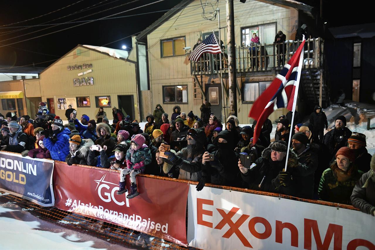 FILE - In this March 18, 2020, file photo, a crowd standing behind ExxonMobile signage watches as Thomas Waerner, of Norway, arrives in Nome, Alaska to win the Iditarod Trail Sled Dog Race. The world's most famous sled dog race has lost another major sponsor as the Iditarod prepares for a scaled-back version of this year's race because of the pandemic, officials said Thursday, Jan. 21, 2021. ExxonMobil confirmed to The Associated Press that the oil giant will drop its sponsorship of the race. (Marc Lester/Anchorage Daily News via AP, File)