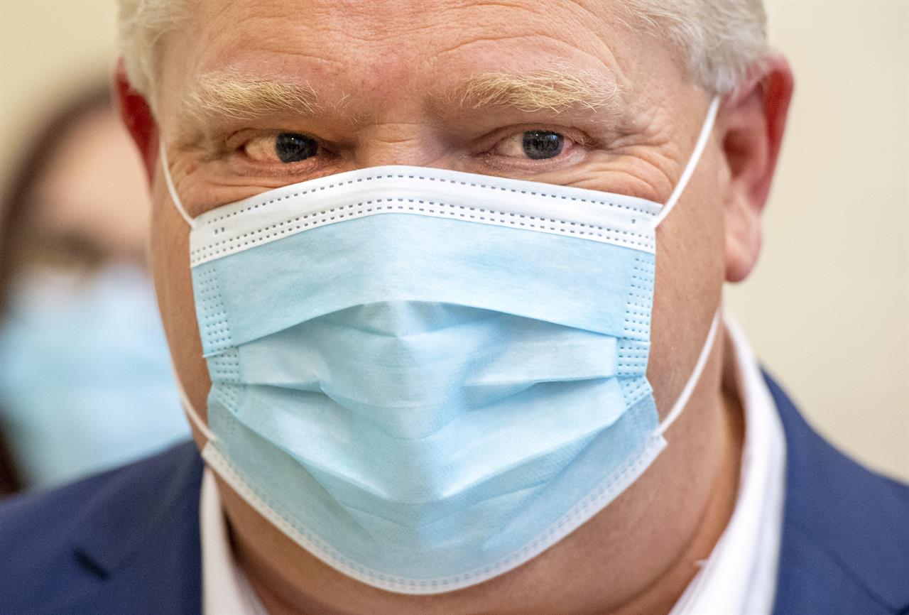 Ontario Premier Doug Ford looks on as a dose of the Pfizer-BioNTech COVID-19 vaccine is administered at The Michener Institute in Toronto on Monday, Jan. 4, 2021. (Frank Gunn/The Canadian Press via AP)