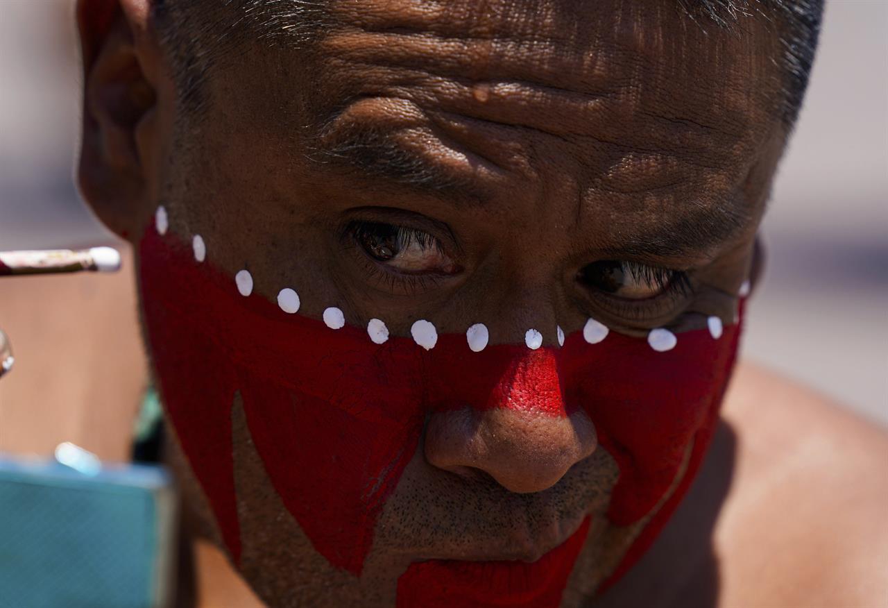 A dancer applies makeup prior to a performance as part of the commemoration marking the 700th founding anniversary of the Aztec city Tenochtitlan, known today as Mexico City, at the main square Zocalo, in Mexico City, Monday, July 26, 2021, amid the new coronavirus pandemic. (AP Photo/Fernando Llano)