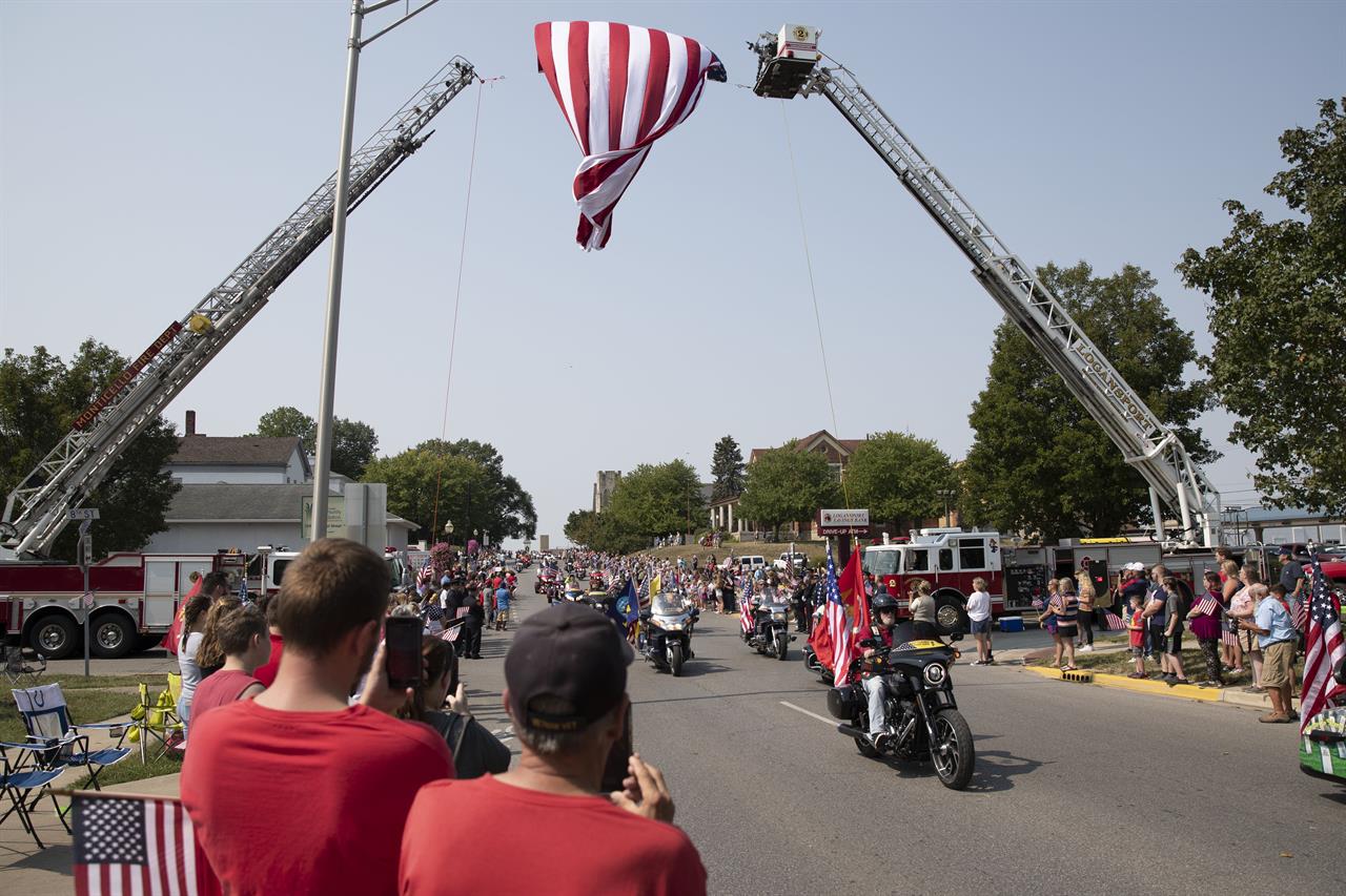 Thousands of people on motorcycles drive past the crowd during the funeral procession for Marine Corps Cpl. Humberto Sanchez on Sunday, Sept. 12, 2021, in Logansport, Ind. Sanchez was among 13 U.S. service members killed in a suicide bombing during the U.S.-run evacuation at Afghanistan’s Kabul airport on Aug. 26. (Christine Tannous /The Indianapolis Star via AP)