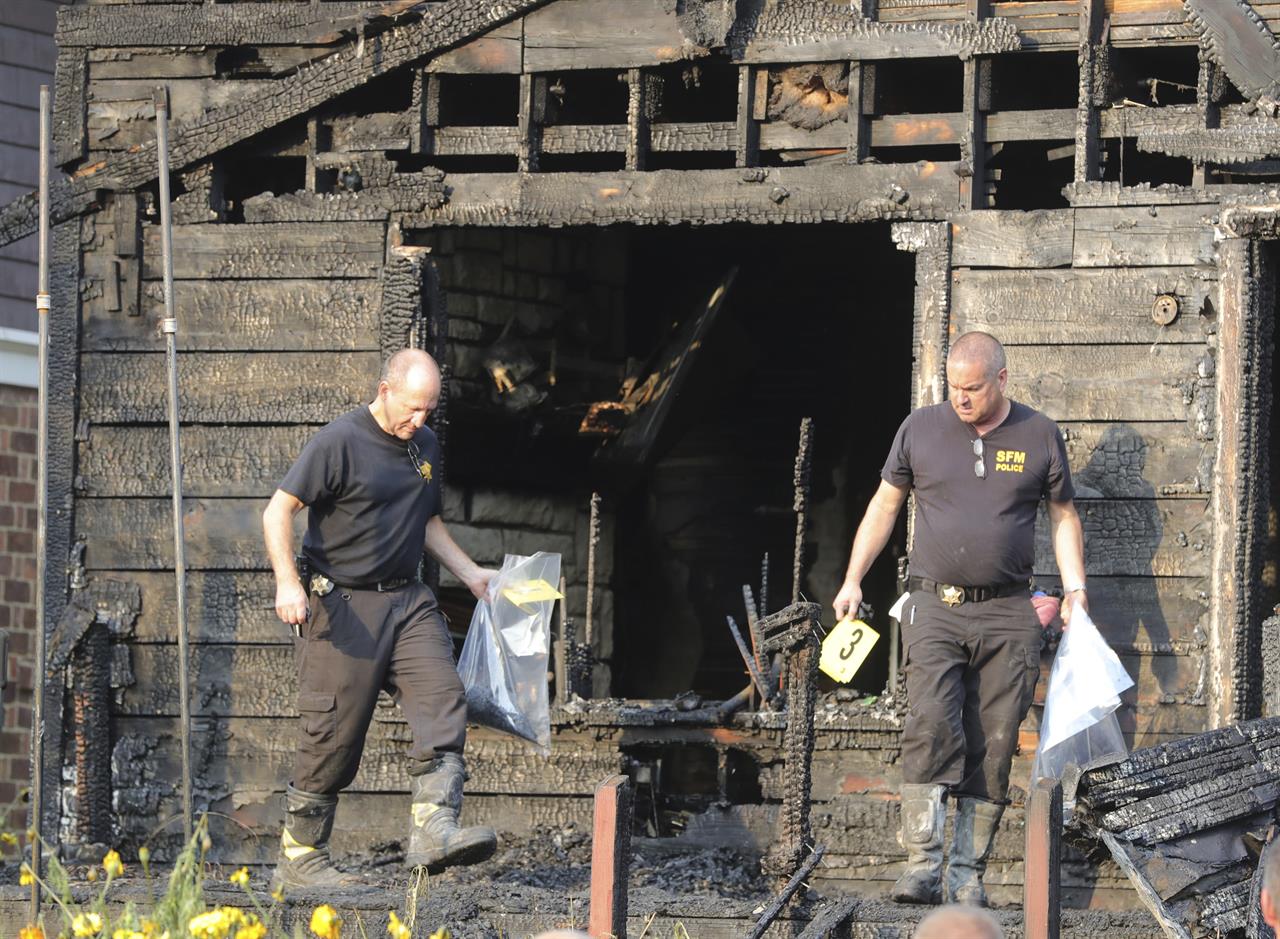 Inspectors from the state fire marshal's office gather evidence at the scene of a fatal fire on Monday, Sept. 13, 2021 in Akron, Ohio. Authorities say five people are dead and four are injured in a house fire in northern Ohio. The Summit County Medical Examiner's Office says two adults and three children were killed. (Phil Masturzo/ Beacon Journal via AP)