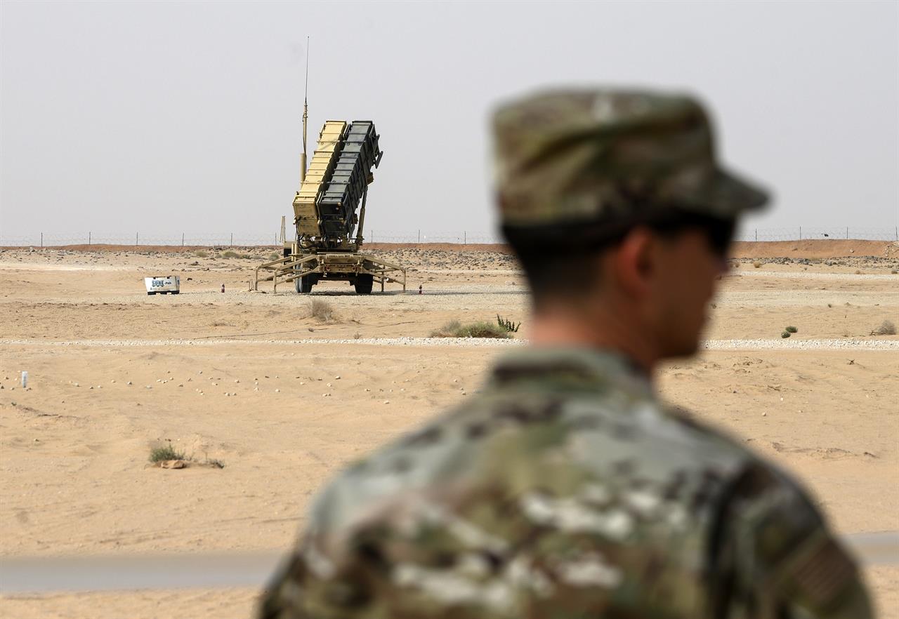 FILE - In this Feb. 20, 2020 file photo, a member of the U.S. Air Force stands near a Patriot missile battery at the Prince Sultan Air Base in al-Kharj, Saudi Arabia. The U.S. military is exploring the possibility using a Red Sea port in Saudi Arabia and an additional two airfields there amid heightened tensions with Iran, the military said Tuesday, Jan. 26, 2021. (Andrew Caballero-Reynolds/Pool via AP, File)