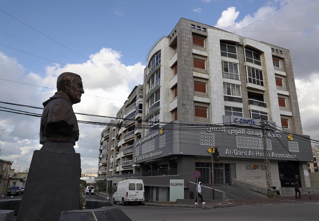 A statue of Iranian General Qassem Soleimani, former head of Iran's Quds force, stands in front of a branch of the Hezbollah-run Qard al-Hassan Association, in Ghobeiry, Lebanon, Wednesday, Jan. 20, 2021. As more Lebanese fall into poverty in the country's economic crisis, increasing numbers are turning to the financial arm of the Iranian-backed Hezbollah militant group for help. Qard al-Hassan provides small, interest-free loans in dollars at a time when Lebanese are desperate for hard currency and commercial banks are not lending. (AP Photo/Bilal Hussein)