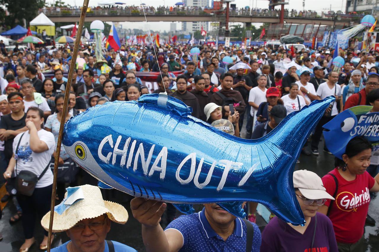 FILE - In this July 22, 2019, file photo, protesters display a balloon with an anti-China message during a rally near the Philippine Congress in Manila, Philippines. The Philippines has protested a new Chinese law that authorizes its coast guard to fire on foreign vessels and destroy other countries' structures on islands it claims, Manila’s top diplomat said Wednesday, Jan. 27, 2021. (AP Photo/Bullit Marquez, File)