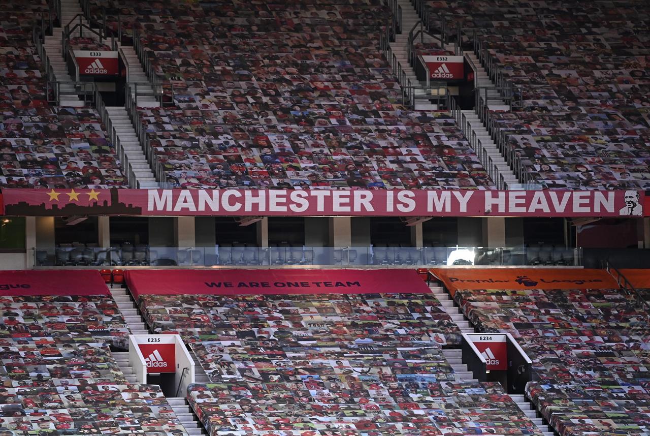 Empty stands are covered with photos of supporters ahead of the English FA Cup 4th round soccer match between Manchester United and Liverpool at Old Trafford in Manchester, England, Sunday, Jan. 24, 2021. (Laurence Griffiths/Pool via AP)