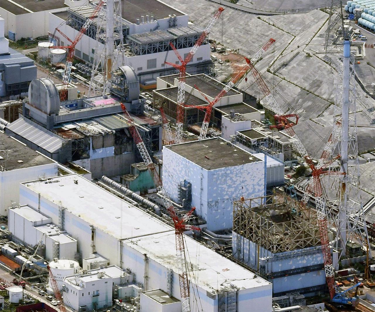 FILE - This Sept. 4, 2017, aerial file photo shows Fukushima Dai-ichi nuclear power plant's reactors, from bottom at right, Unit 1, Unit 2 and Unit 3, in Okuma, Fukushima prefecture, northeastern Japan. A draft investigation report into the 2011 Fukushima nuclear meltdown, adopted by Japanese nuclear regulators Wednesday, Jan. 27, 2021, says it has detected dangerously high levels of radioactive contamination at two of the three reactors, adding to concerns about decommissioning challenges. The interim report said data collected by investigators showed that the sealing plugs sitting atop the No. 2 and 3 reactor containment vessels were as fatally contaminated as nuclear fuel debris that had melted and fell to the bottom of the reactors following the March 2011 tsunami and earthquake. (Daisuke Suzuki/Kyodo News via AP, File)