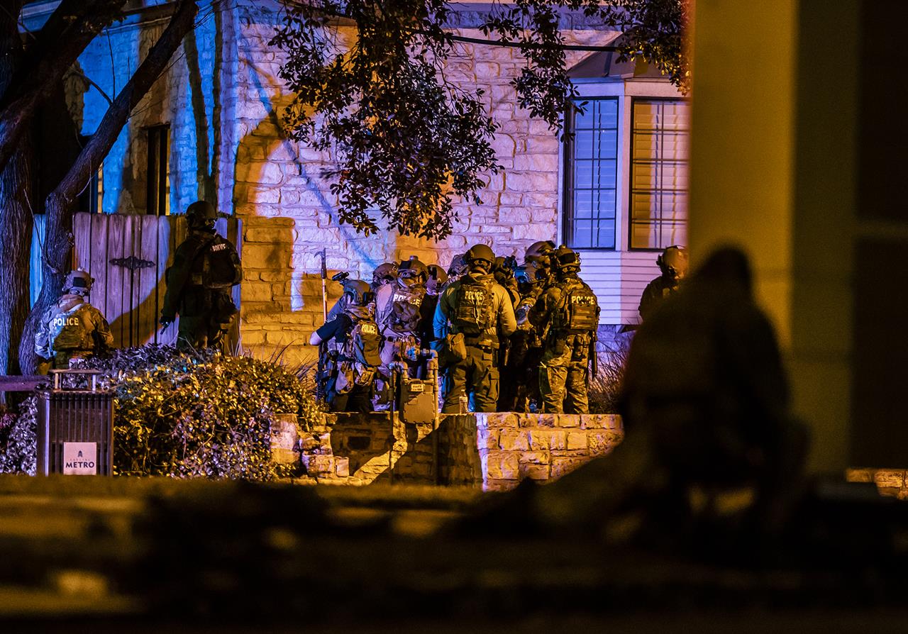 Police begin to enter a building as they respond to hostage situation at doctor's office in Austin, Texas, where, police said, two people were found dead after police entered the building Tuesday, Jan. 26, 2021. After several hours of trying to reach the people inside the building, the Austin Police Department had a robot unit go in and identified a victim, officials said. (Ricardo B. Brazziell/Austin American-Statesman via AP)