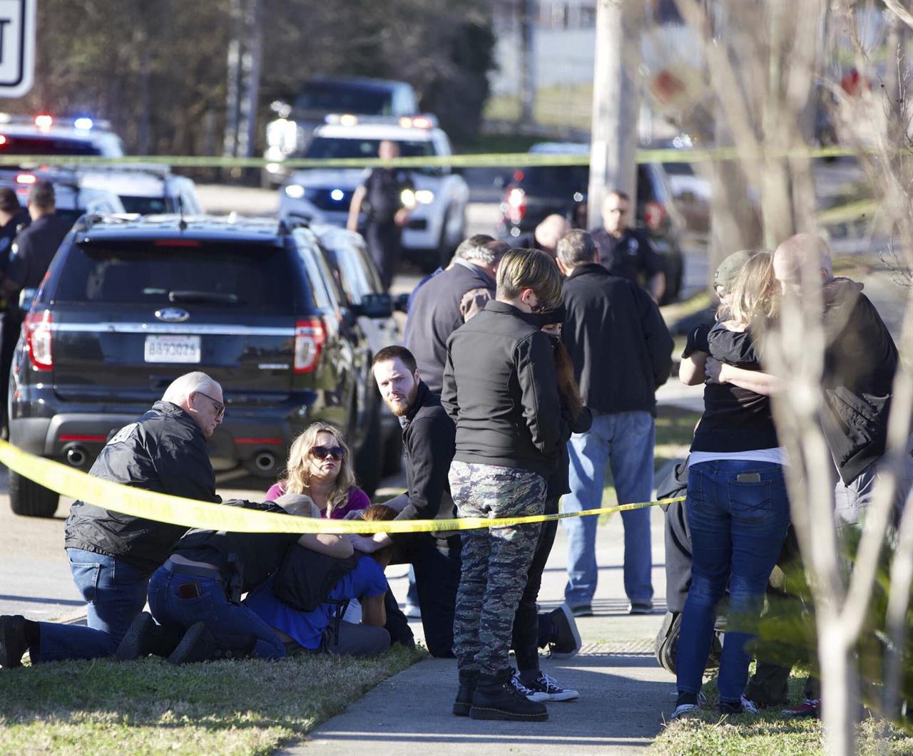 People are comforted by law enforcement as the Jefferson Parish Sheriff's Office deputies investigate a shooting at the Jefferson Gun Outlet in Metairie, La. Saturday, Feb. 20, 2021. A suspect fatally shot two people at a gun store in a suburb of New Orleans on Saturday afternoon, and the shooter also died during gunfire as others engaged the suspect both inside and outside the outlet, authorities said. (Sophia Germer/The Times-Picayune/The New Orleans Advocate via AP)