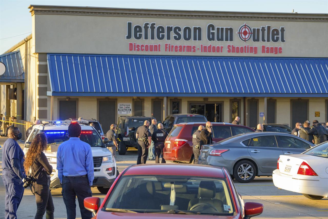 Bystanders react at the scene of a multiple fatality shooting at the Jefferson Gun Outlet in Metairie, La., Saturday, Feb. 20, 2021. A suspect fatally shot two people at a gun store in a suburb of New Orleans on Saturday afternoon, and the shooter also died during gunfire as others engaged the suspect both inside and outside the outlet, authorities said. (AP Photo/Matthew Hinton)
