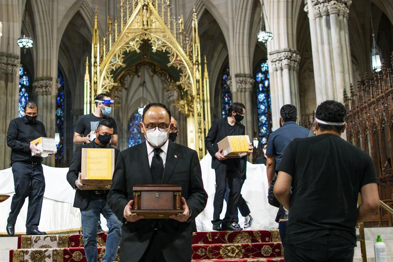 Jorge Islas Lopez, Consul General of Mexico, and others carry the remains of loved ones following the blessing of the ashes of Mexicans who died from COVID-19 at St. Patrick's Cathedral, Saturday, July 11, 2020, in New York. The ashes were blessed before they were repatriated to Mexico. (AP Photo/Eduardo Munoz Alvarez)