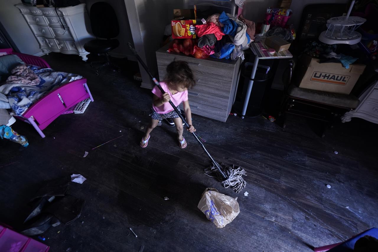 Raella Mills, 3, plays mop-up at her home Tuesday, Feb. 23, 2021, in Dallas. Raella and her mother's apartment flooded last week by a pipe that burst during the record winter cold. They are still without running water. (AP Photo/LM Otero)