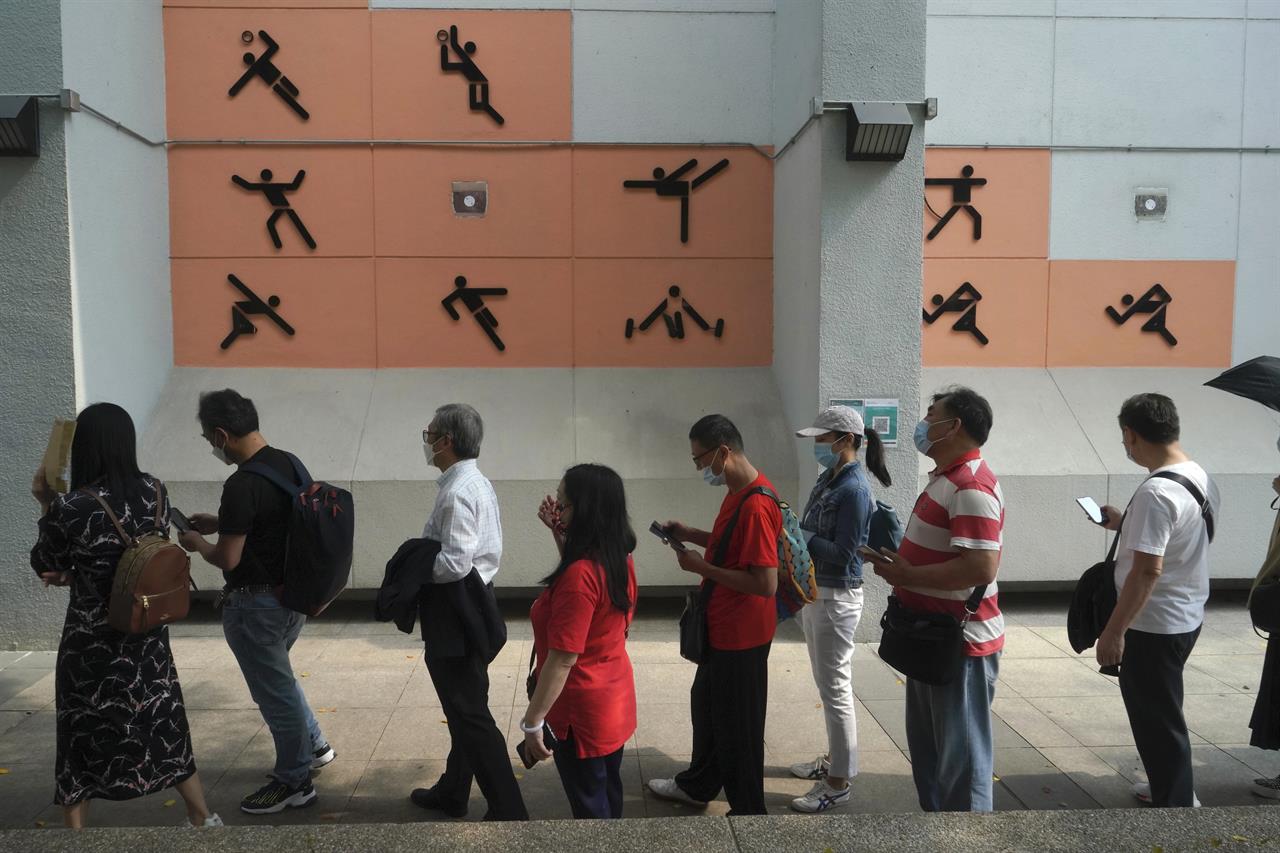 People line up to receive the China's Sinovac COVID-19 coronavirus vaccine at a community vaccination centre in Hong Kong, Friday, Feb. 26, 2021. Hong Kong began administering its first COVID-19 vaccines to the public Friday, kicking off its program offering free vaccinations to all 7.5 million residents. (AP Photo/Kin Cheung)