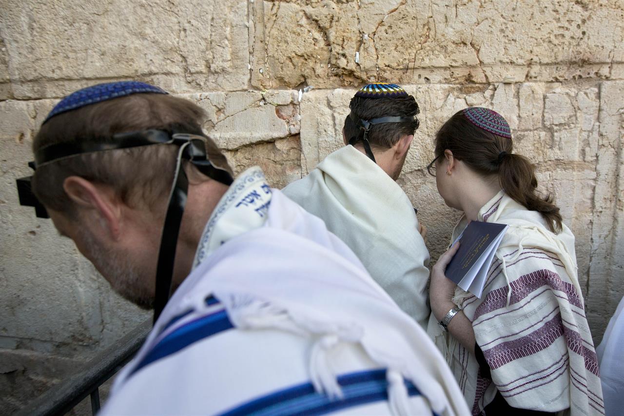 FILE - In this Feb. 25, 2016 file photo, American and Israeli Reform rabbis pray at the Western Wall, the holiest site where Jews can pray in Jerusalem's old city. Israel's Supreme Court on Monday, March 1, 2021, dealt a major blow to the country's powerful Orthodox establishment, ruling that people who convert to Judaism through the Reform and Conservative movements in Israel also are Jewish and entitled to become citizens. (AP Photo/Sebastian Scheiner, File)