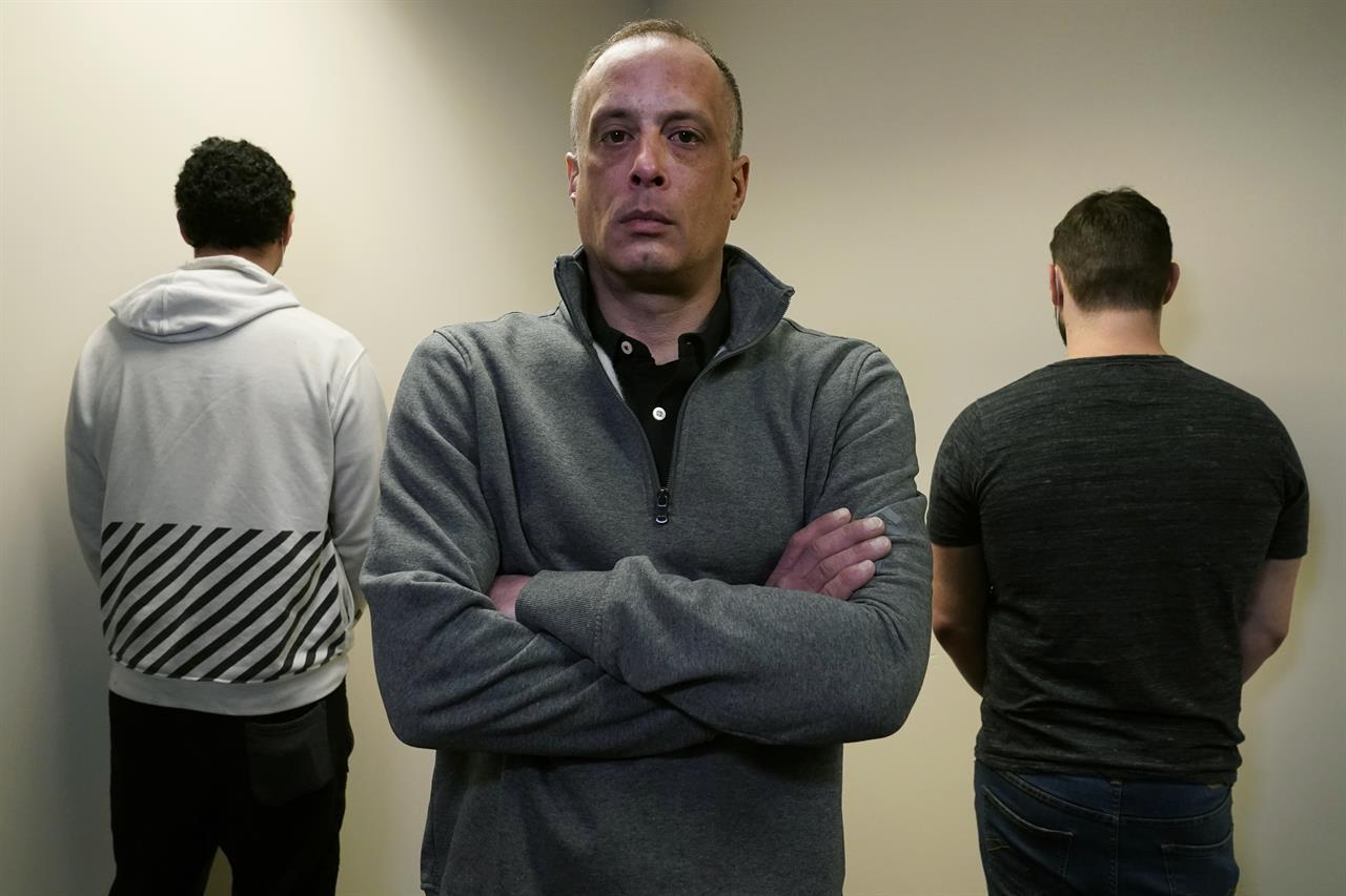 David Meehan, center, the lead plaintiff in a class-action lawsuit accusing the State of New Hampshire of covering up decades of sexual, physical and emotional abuse at its youth detention center, poses with two other victims who did not want to be identified, at his lawyer's office, Thursday, Feb. 18, 2021, in Portsmouth, N.H. Meehan accuses three staffers, one who later worked for the Boston Red Sox, of sexually assaulting him, and others of witnessing and enabling the abuse. The lawsuit against the state now spans six decades, with 150 staffers accused of physically or sexually abusing 230 children. (AP Photo/Charles Krupa)