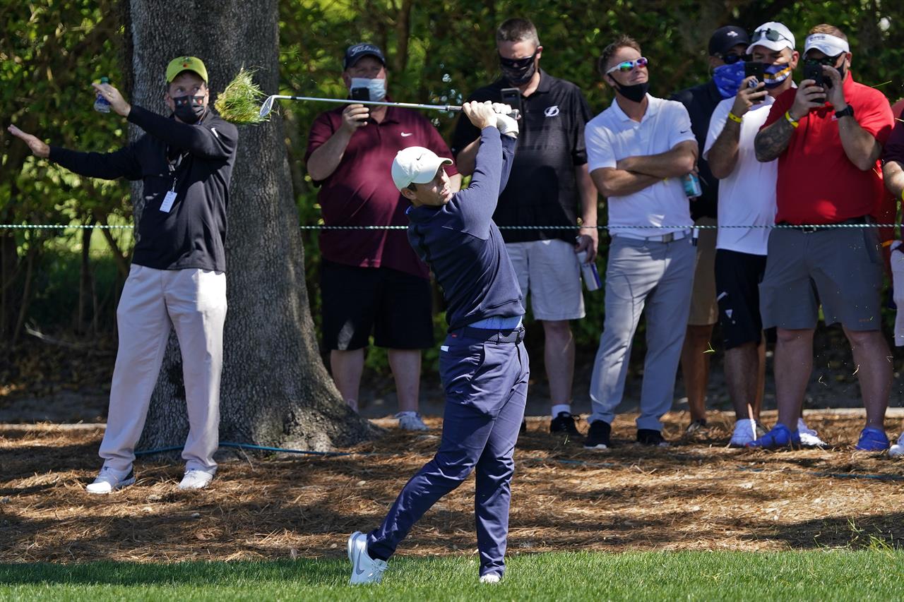 Rory McIlroy, of Northern Ireland, hits from the rough in front of the gallery on the ninth hole during the first round of the Arnold Palmer Invitational golf tournament Thursday, March 4, 2021, in Orlando, Fla. (AP Photo/John Raoux)