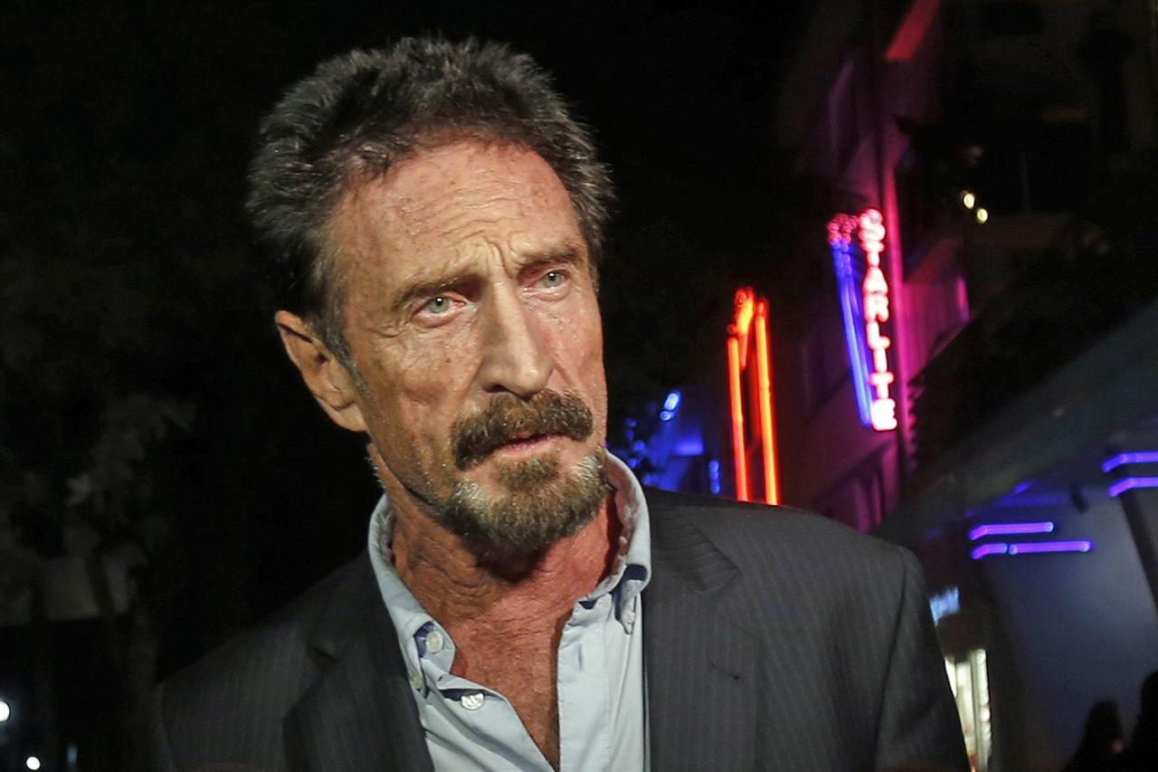 FILE — In this Dec. 12, 2012 file photo, anti-virus software founder John McAfee answers questions to reporters as he walks on Ocean Drive, in the South Beach area of Miami Beach, Fla. McAfee was indicted on fraud and money laundering conspiracy charges alleging that he and cohorts made over $13 million by fooling investors zealous over the emerging cryptocurrency market, authorities said Friday, March 5, 2021. (AP Photo/Alan Diaz, File)