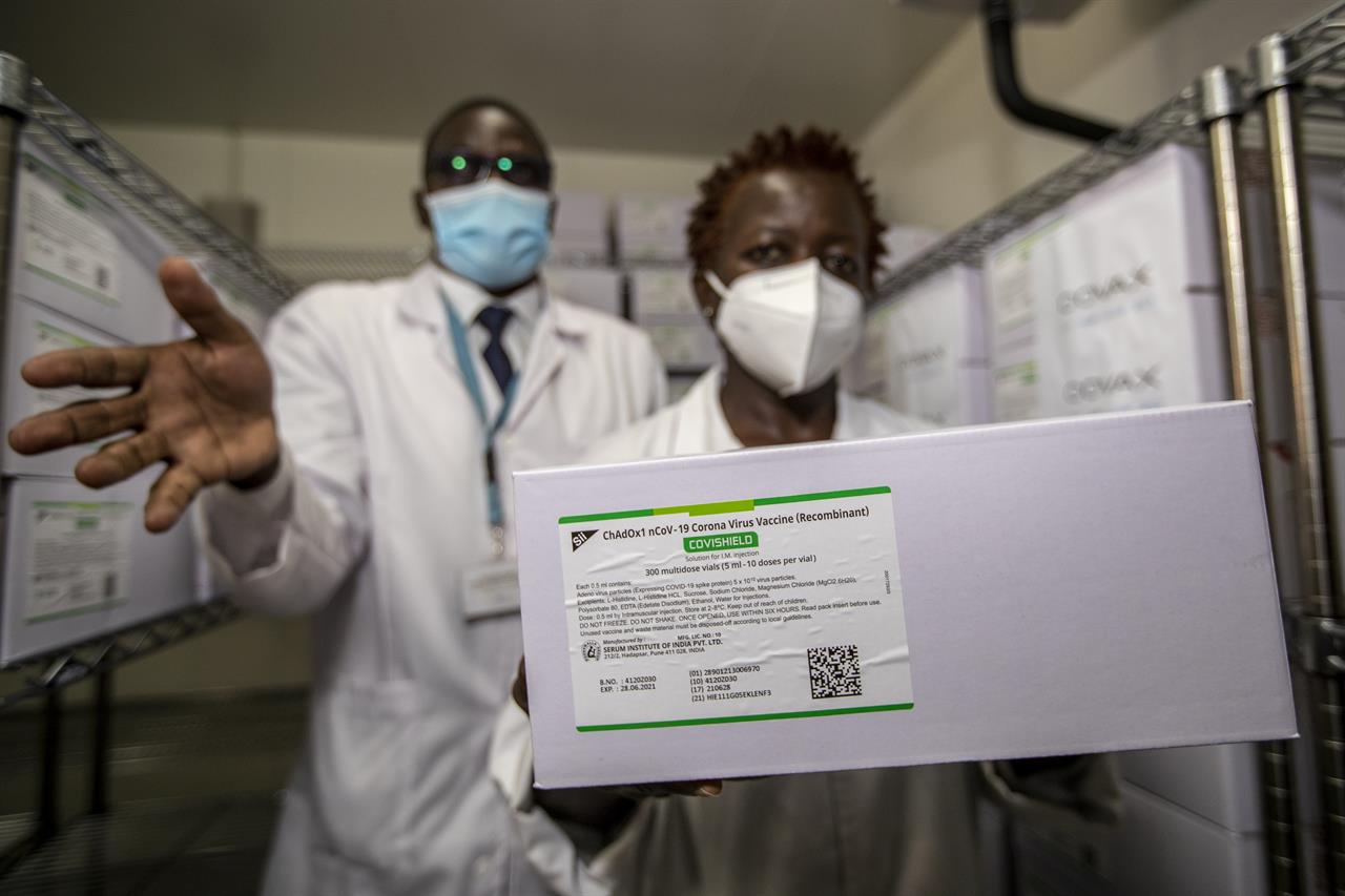 Technicians show a carton of AstraZeneca COVID-19 vaccine manufactured by the Serum Institute of India, inside a cold storage room at the central vaccine depot in Kitengela town on the outskirts of Nairobi, in Kenya Thursday, March 4, 2021. Around 1.02 million doses of the AstraZeneca COVID-19 vaccine arrived in the country on Wednesday as part of the COVAX facility. (AP Photo/Ben Curtis)