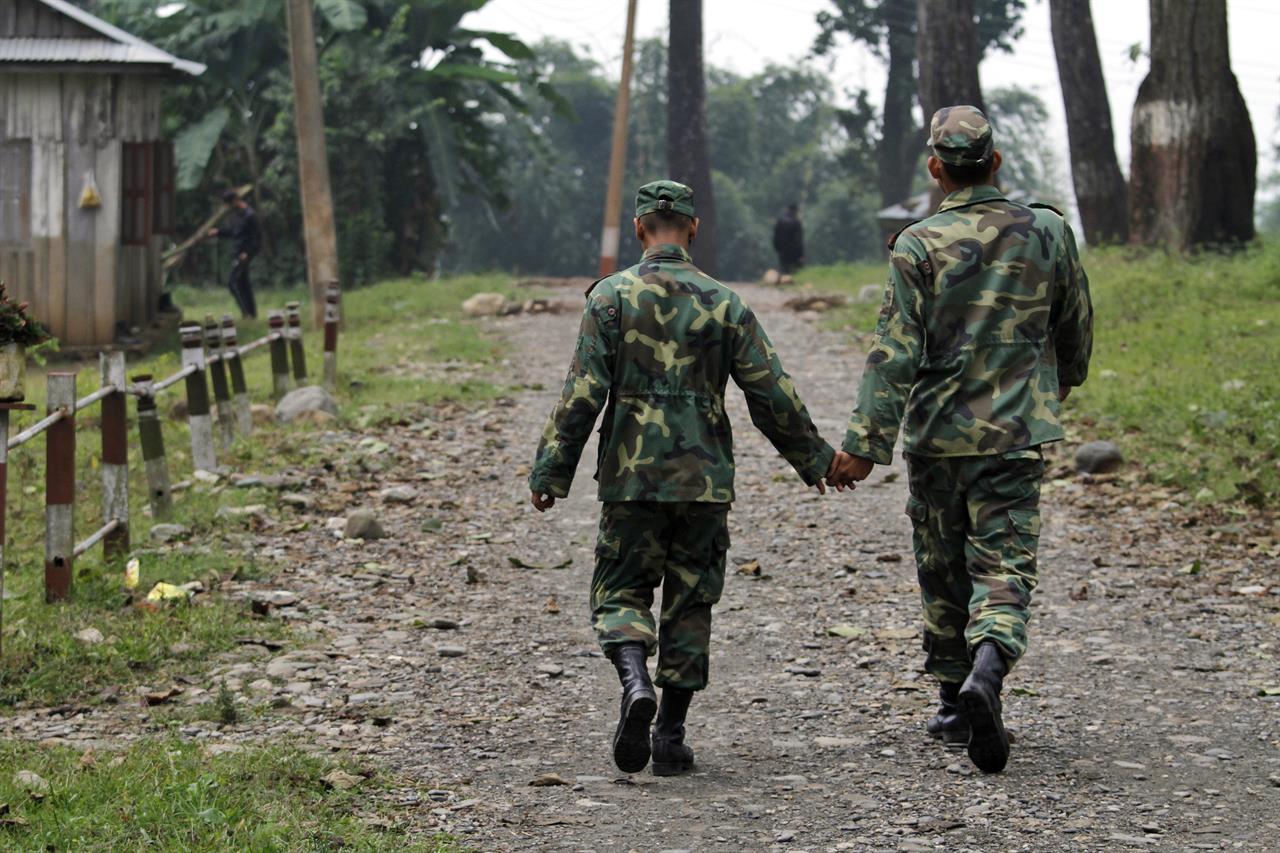 FILE - In this Nov. 18, 2011, file photo, former Maoist communist rebels walk together at the Shaktikhor cantonment in Chitwan, about 220 kilometers (138 miles) southwest of Katmandu, Nepal. Nepal’s government signed a peace agreement Thursday with a small communist rebel group widely feared because they were known for violent attacks, extortion and bombings. (AP Photo/Niranjan Shrestha, File)