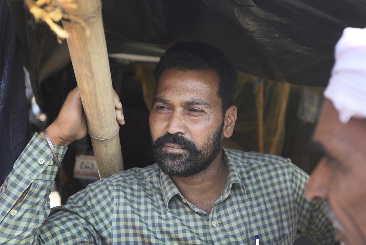 Indian farmer Sangtar Singh rests at the back of his tractor trolly in Singhu, along the Delhi-Haryana border, Friday, March 5, 2021. Thousands of demonstrating Indian farmers blocked a massive expressway on the edges of capital New Delhi on Saturday to mark the 100th day of protest against agricultural laws passed last year that they say will devastate their income. The mood at the protest site in Singhu border was boisterous on Friday, with many farmers settling into their surroundings for the long haul. Huge soup kitchens that feed thousands daily were still running. Thousands of farmers thronged both sides of the highway and hundreds of trucks have been turned into rooms, fitted with water coolers in preparation for the summer. Electric fans and air conditioners are also being installed in some trailers. (AP Photo/Manish Swarup)