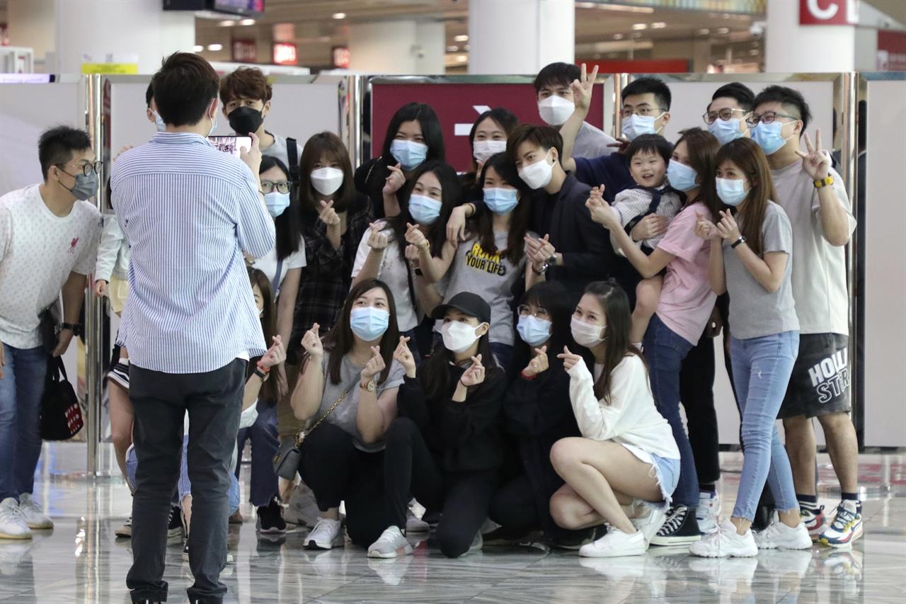 Malaysians and Singaporeans stranded in Macao during pandemic, pose for a photo before getting on a special AirAsia flight to Kuala Lumpur, in Macao airport, Thursday, April 8, 2021. About 50 people of various nationalities boarded a chartered flight from Macao to Malaysia on Thursday after many were stranded for months by the pandemic and border restrictions. (AP Photo)