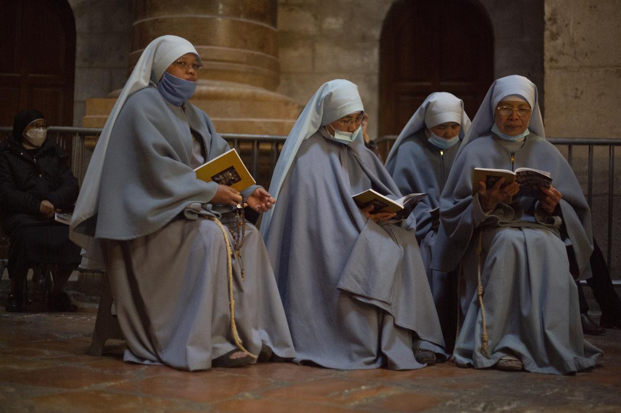 Nuns pray in the Church of the Holy Sepulchre, traditionally where many Christians believe Jesus Christ was crucified, buried and rose from the dead, during the Holy Saturday Easter Vigil procession in Jerusalem's old city, Saturday, April 3, 2021. (AP Photo/Ariel Schalit)