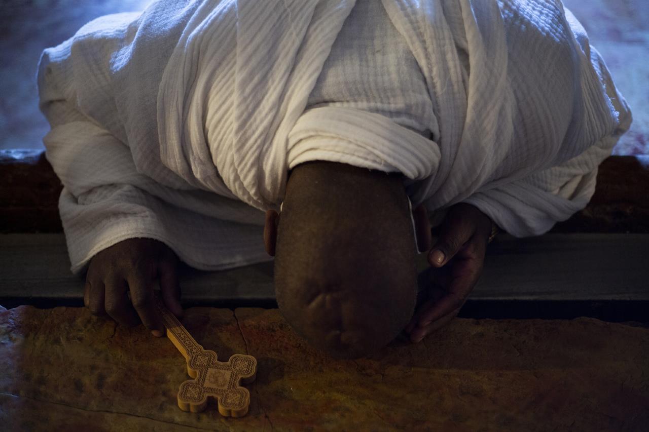 A Christian worshipper prays in the Church of the Holy Sepulchre, traditionally where many Christians believe Jesus Christ was crucified, buried and rose from the dead, during the Holy Saturday procession in Jerusalem's old city, Saturday, April 3, 2021. (AP Photo/Ariel Schalit)